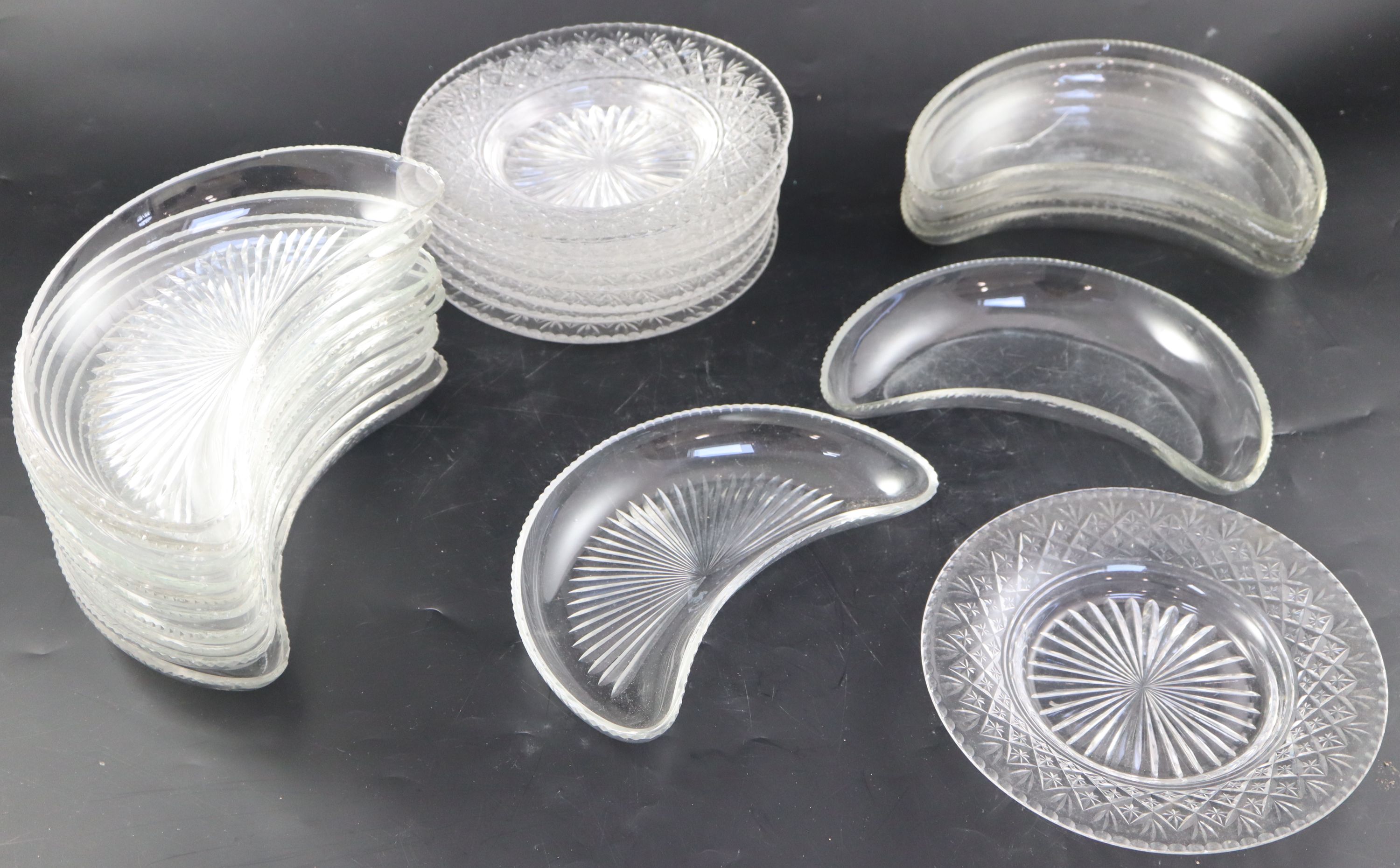 A set of twelve cut glass crescent shaped hors doeuvres dishes,